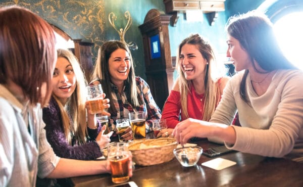 Happy women drinking beer at brewery restaurant - Female friends